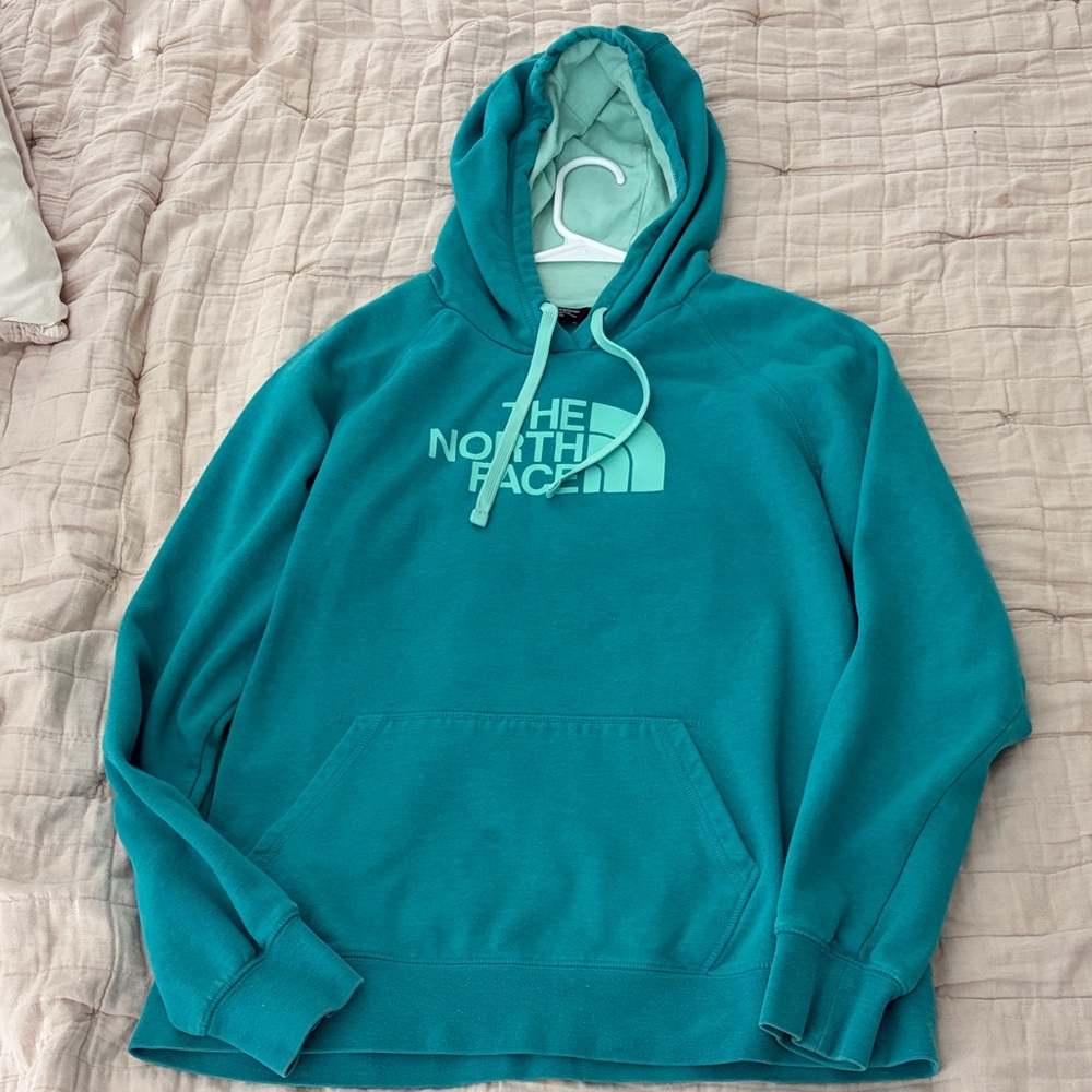 Women’s The North Face Turquoise Hoodie, size XL, two small spots as shown.
